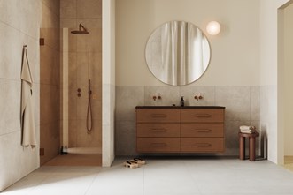 Stenvide Hay 60x60 -laatta yhdistettynä Terra Solid 140D -kalusteeseen sävyssä Dark Oak ja Arc 2 -suihkuseinään, jossa Brushed Bronze -yksityiskohdat.